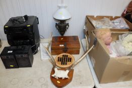 A wrought iron oil lamp; a pair of antlers mounted