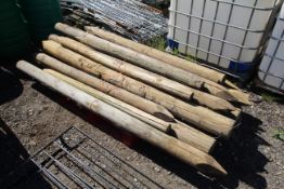 Quantity of various round fence posts.
