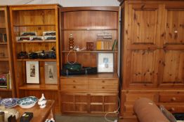 A teak wall unit raised on cupboard base fitted fo