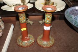 A pair of terracotta candlesticks with Grecian ena