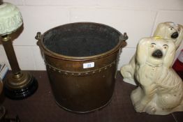 An antique copper coal bucket with swing handle
