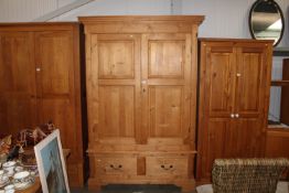 A modern pine two door wardrobe fitted two drawers