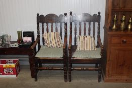 A pair of oak slat back elbow chairs