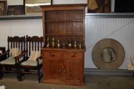 A pine dresser raised on cupboard base fitted two