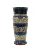 A large Doulton stoneware baluster stick stand, with raised foliate decoration on a mottled blue and