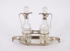 A George III silver cruet stand, of oval boat shape with lion mask ring handles together with a