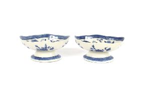 A pair of Chinese pedestal dishes, decorated foliate sprays and artifacts, 24cm long