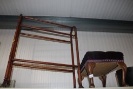 A towel rail and a purple upholstered stool