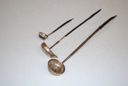 Two toddy ladles inset with coins and a silver pu