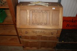 An oak linen fold decorated bureau fitted single d