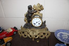 A brass cased mantel clock with figural decoration