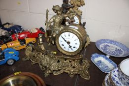 A brass cased mantel clock with figural decoration