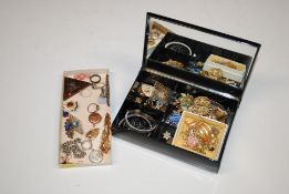 A lacquered jewellery box and contents of various