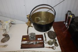 A brass preserve pan, a wooden desk stand, mother of pearl handled cutlery, a brass door knocker,