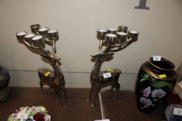 A pair of metalware tea light holders in the form