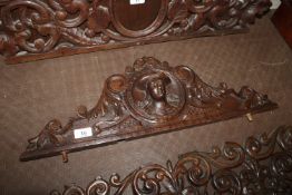 An antique carved oak pediment with figurehead dec