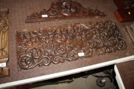An antique carved and pierced hardwood panel with floral and urn decoration around a central cross