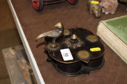 An Eastern brass container of shaped design with bird finial