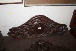 A carved oak pediment with scrolled leaf decoratio
