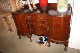 A reproduction mahogany break front sideboard fitted three drawers, flanked by cupboards raised on