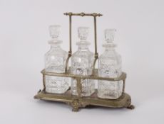A Victorian plated three bottled tantalus with swing handle raised on paw feet, 42cm