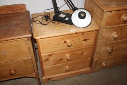 A stripped pine bedside chest fitted three drawers