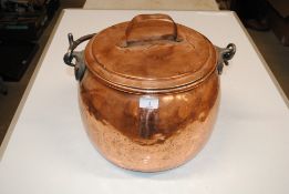 A large antique copper cauldron with lid and swing