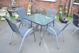 Glass Topped Metal Patio Table with Four Stacking