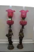 Pair of Victorian Oil Lamps with Brass Classical Figures and Cranberry Glass Reservoirs and Shades