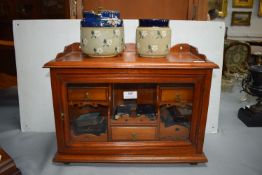 Edwardian Oak Glazed Smokers Cabinet Containing Pipes, Lighters, and Two Tobacco Jars