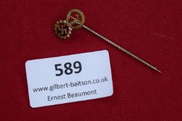 A small German enamel stick pin featuring cogwheel with swastika and wheat ear motif, symbolising