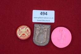 Three event badges: a red and cream enamelled plastic badge for Kreistag Hildesheim 1931; a bronze