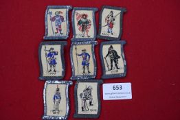 A set of seven German WHW donation badges, each with embroidered soldier designs dated from 1510