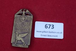 A rectangular bronze-coloured event badge with eagle/swastika above inscription “Nat.-Soz.