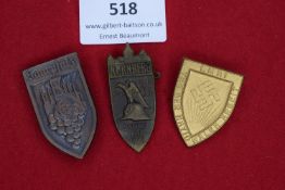 A group of three shield-shaped badges, including Saarpfalz industrial and grapes motif, Nürnberg