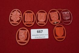 A group of seven red celluloid day badges, each with crest and town name: Hultschin, Eupen, Linz,