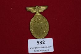 A 1934 SA Aufmarsch Standarte 141 badge, gilt oval example surmounted by eagle and swastika,