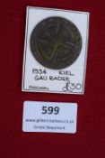 1934 Kiel Gau Badge, circular bronze badge with swastika and runic design, inscribed Gautagung