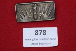 GDA J.B. Badge – A rectangular metal badge featuring the initials 
