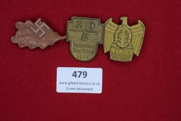 Three event badges: a pressed brown card badge in oakleaf form for an NSDAP rally at Hegenscheidt,