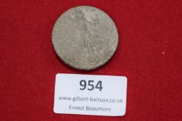 A circular pressed alloy badge, obverse depicting a stylised figure of an athlete holding aloft a