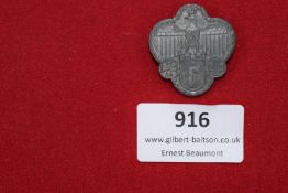 German Eagle & Crosses Badge – A clover-shaped pressed metal badge with eagle and swastika flanked