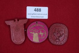 Three plastic badges: an eagle-topped tinnie for Gautreffen 1937, Gau Kurhessen; a circular