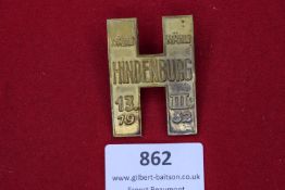 Rectangular brass badge in the form of a stylised 