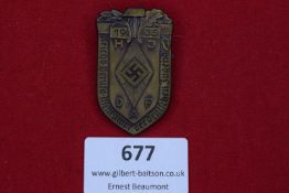 Shield-shaped bronze-coloured badge with oak leaves and hammer motif, central HJ diamond with
