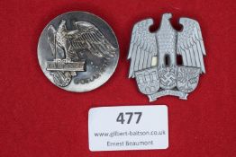 Two event badges: a silvered circular tinnie for Blut und Boden, Goslar 1937, featuring eagle with