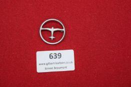 A lightweight circular badge featuring the silhouette of an early aircraft within a ring, finished