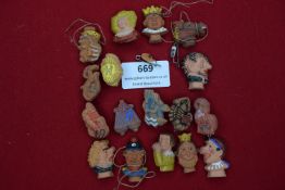 A mixed selection of small ceramic and terracotta badges, some painted, depicting busts, comic