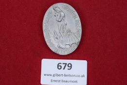 An oval aluminium badge commemorating the 1935 Saar plebiscite, showing St. George slaying the