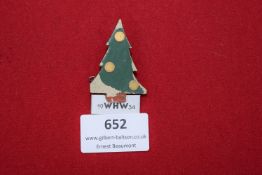 A painted wooden badge in the form of a decorated Christmas tree, inscribed 